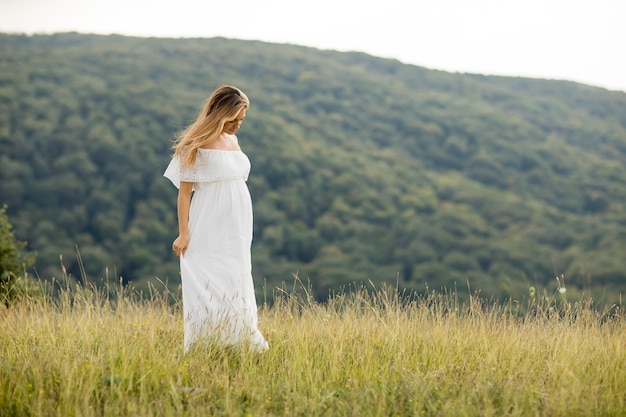 Jeune femme enceinte se détendre à l&#39;extérieur dans la nature