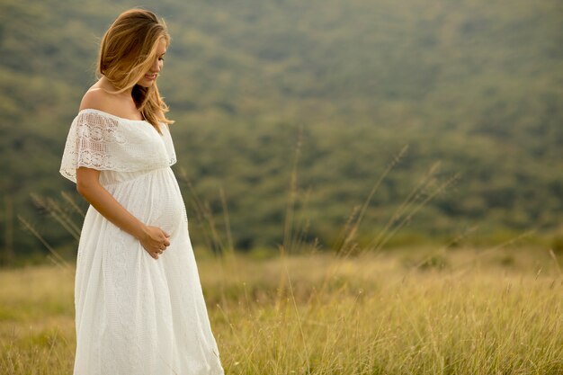 Jeune femme enceinte se détendre à l&#39;extérieur dans la nature