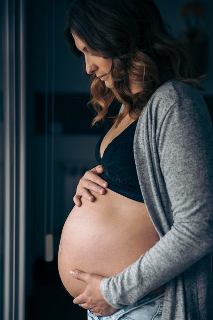 Jeune femme enceinte se regardant et touchant son ventre