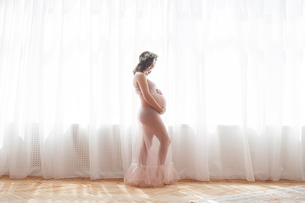 Jeune femme enceinte séduisante à la maison. Gros plan photo d'une femme enceinte.