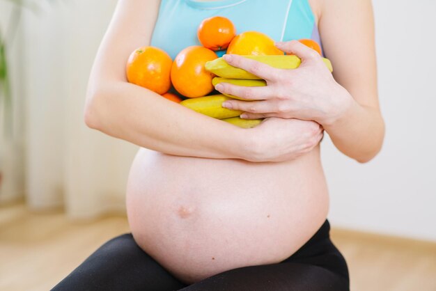 Une jeune femme enceinte tenant des fruits