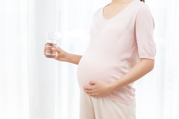 Jeune femme enceinte avec un verre d'eau