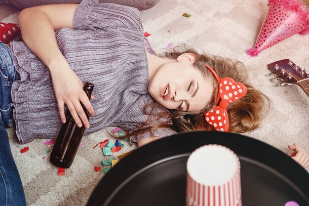 Jeune femme endormie après la fête à la maison