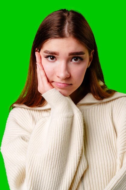 Photo une jeune femme ennuyée et désintéressée sur un fond vert.