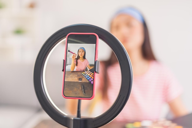 Jeune femme enregistrant une vidéo de maquillage