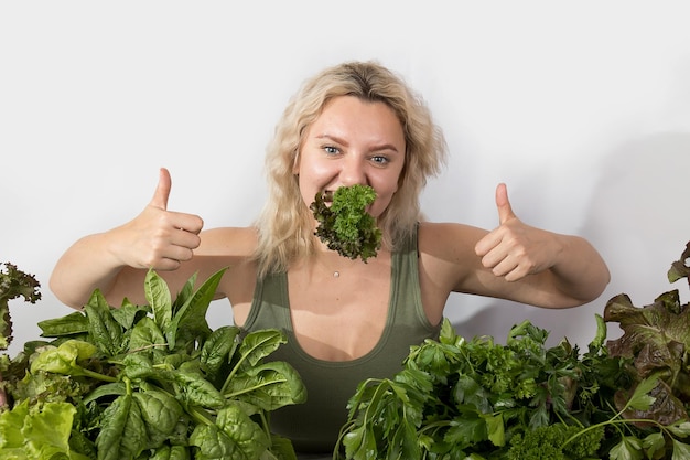 Jeune femme avec un ensemble d'ingrédients verts laitue épinards pour une alimentation saine