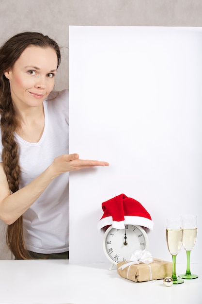 Photo jeune femme entre 30 et 40 ans en chapeau de père noël