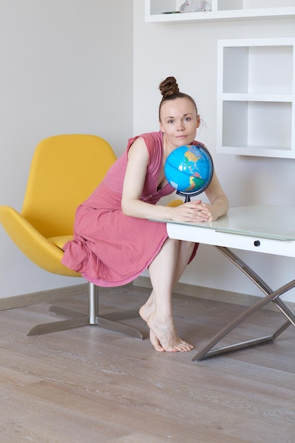 Jeune femme entre 30 et 40 ans avec un globe