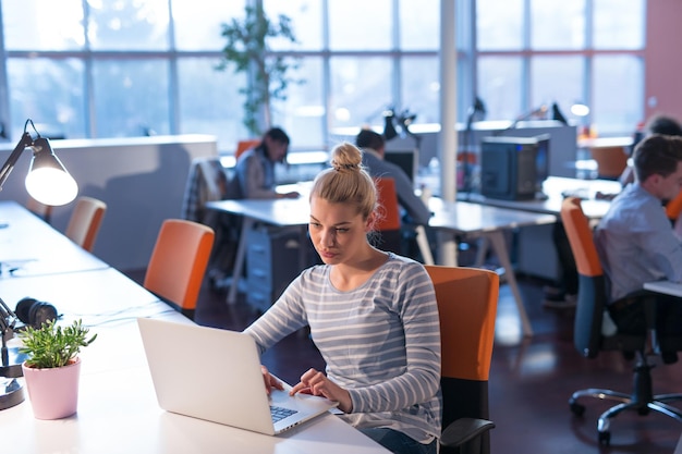 Jeune femme entrepreneur indépendante travaillant à l'aide d'un ordinateur portable dans un espace de coworking