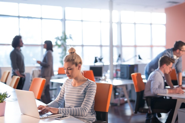 Jeune femme entrepreneur indépendante travaillant à l'aide d'un ordinateur portable dans un espace de coworking