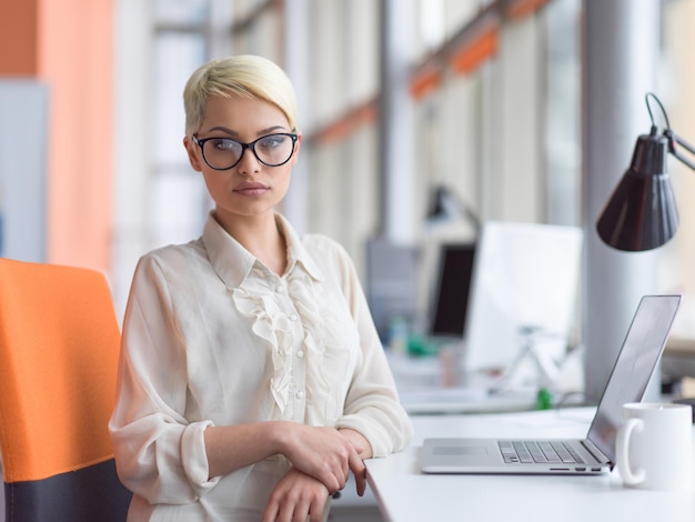 Jeune femme entrepreneur indépendante travaillant à l'aide d'un ordinateur portable dans un espace de coworking