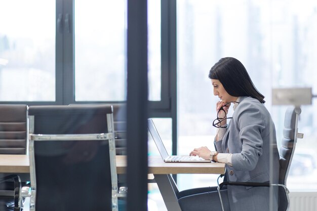 Jeune femme entrepreneur indépendante travaillant à l'aide d'un ordinateur portable dans un espace de coworking