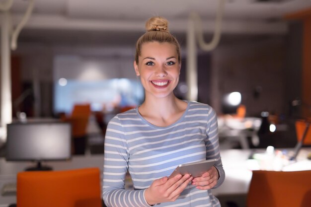 jeune femme entrepreneur travaillant sur tablette numérique au bureau de nuit