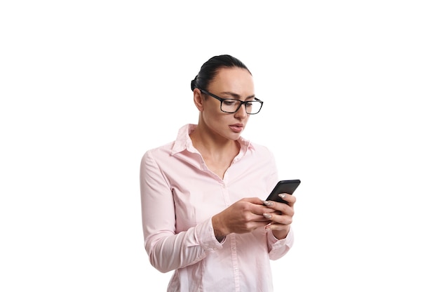 Jeune femme envoyant un message sur téléphone mobile, isolé sur fond blanc avec espace de copie