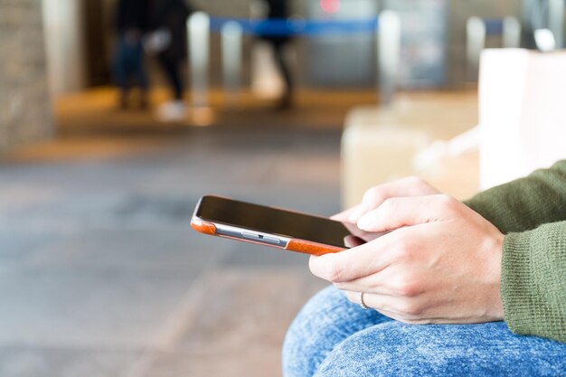 Jeune femme envoyant un message sur un téléphone portable