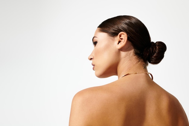 Une jeune femme équilibrée mettant en valeur l'élégance avec une coiffure simple et un décor minimaliste