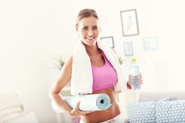 jeune femme avec des équipements sportifs à la maison.