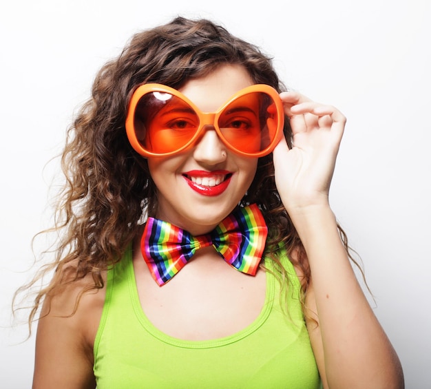 Jeune femme espiègle avec des lunettes de fête