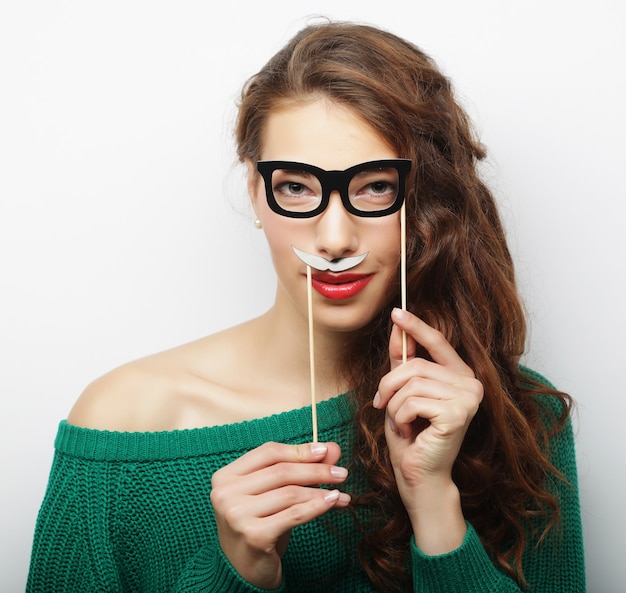 Jeune Femme Espiègle Tenant Des Lunettes De Fête Et Une Fausse Moustache