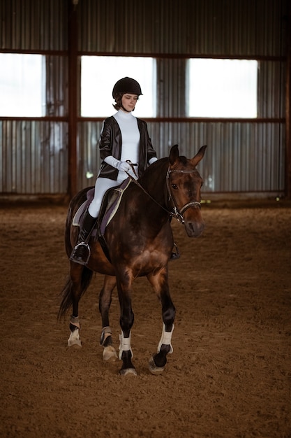 Jeune femme est engagée dans les sports équestres, la formation à cheval