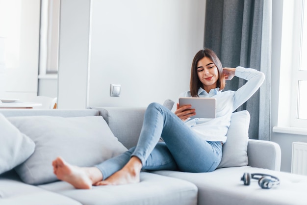 La jeune femme est à l'intérieur dans la chambre de la maison moderne pendant la journée