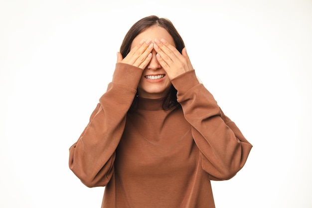 La jeune femme est prête pour une surprise tout en couvrant les yeux avec ses mains