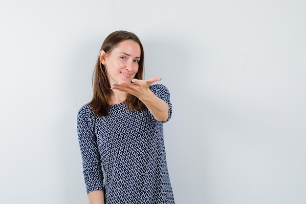 Jeune femme étendant ses mains sur fond blanc