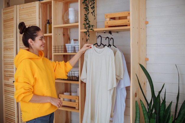 Jeune femme étendant des vêtements dans le placard à la maison