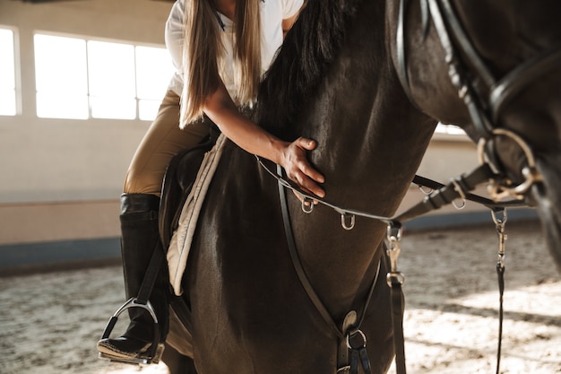 Jeune femme étonnante à cheval dans la campagne