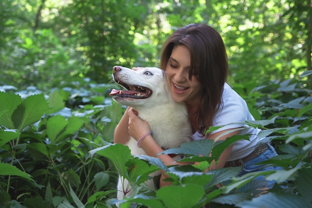 Jeune femme étreignant et tapotant son chien