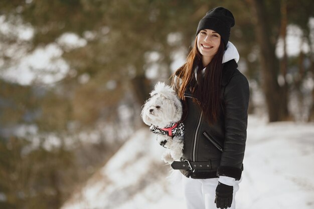 Une jeune femme étreint son chien en plein air.