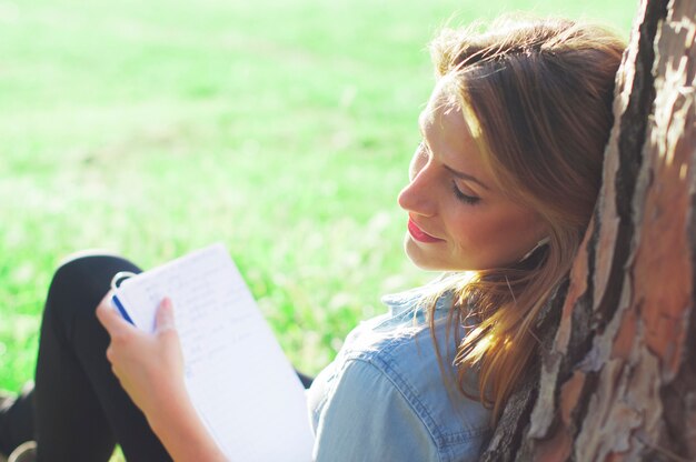 Jeune femme étudiant dans le parc