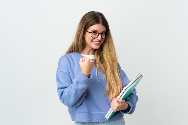 Jeune femme étudiante blonde isolée sur fond blanc célébrant une victoire