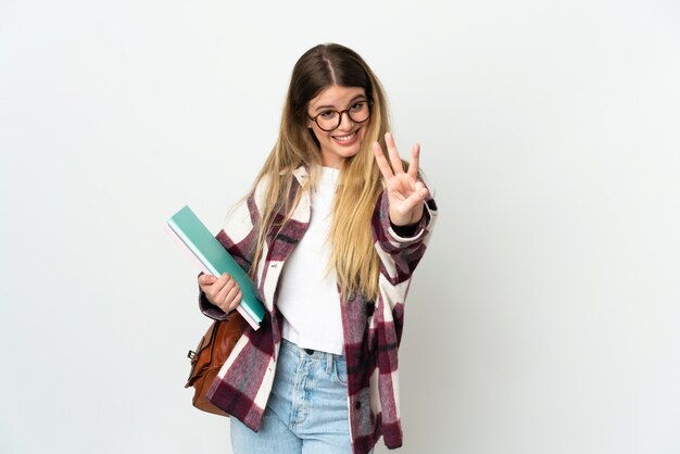 Jeune femme étudiante blonde posant isolée contre le mur blanc