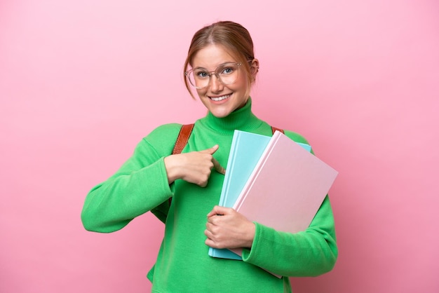 Jeune femme étudiante caucasienne isolée sur fond rose avec une expression faciale surprise