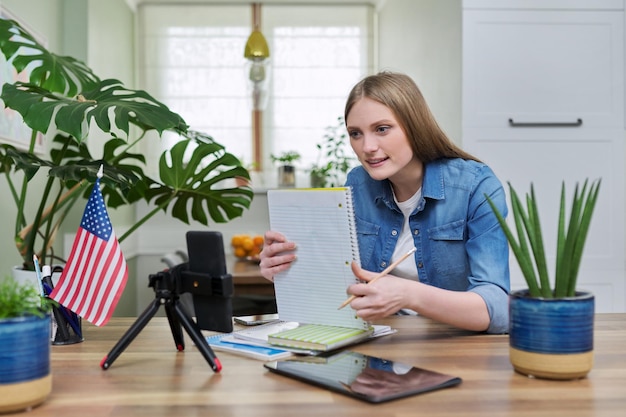 Jeune femme étudiante étudiant à la maison en ligne à distance Fond de drapeau des États-Unis