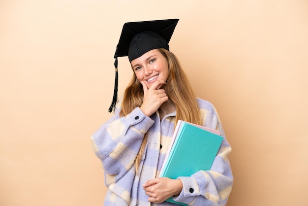 Jeune femme étudiante sur fond isolé heureux et souriant