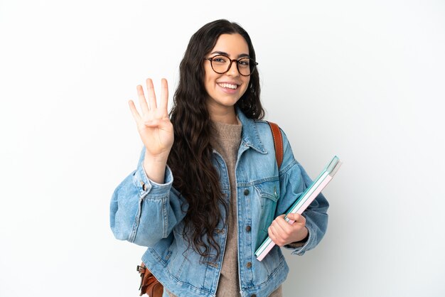 Jeune femme étudiante isolée sur fond blanc heureux et comptant quatre avec les doigts