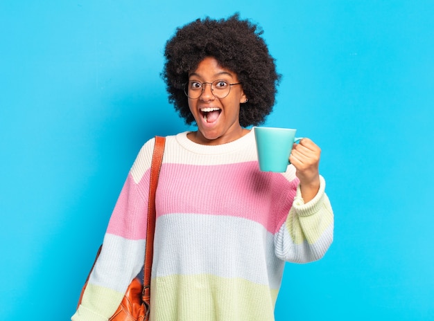 Jeune femme étudiante pré afro avec une tasse de café