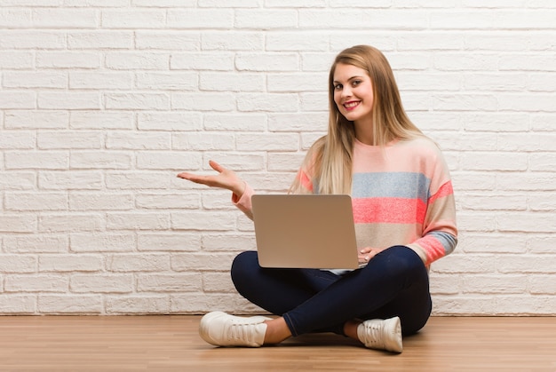 Jeune femme étudiante russe assise tenant quelque chose avec les mains