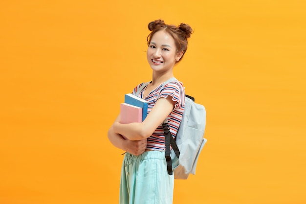 Jeune femme étudiante souriante confiante et croisant les bras levant les yeux