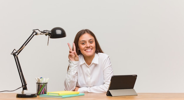 Jeune femme étudiante travaillant sur son bureau, doutant et confus