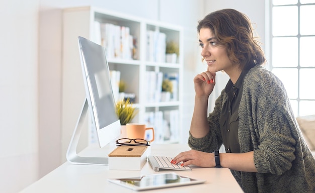 Jeune femme ou étudiante utilisant une tablette à la maison