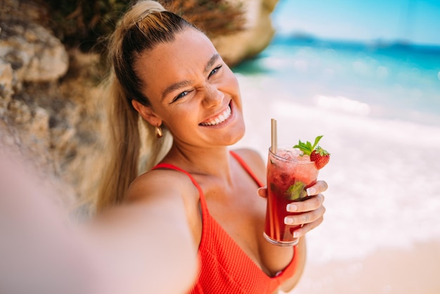 Jeune femme européenne en bikini sur la plage en été Fille à l'aide de son smartphone Prendre des photos selfie