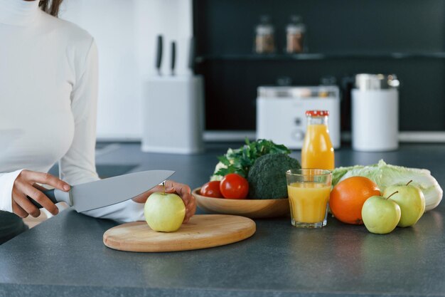 Jeune femme européenne est à l'intérieur à la cuisine à l'intérieur avec des aliments sains