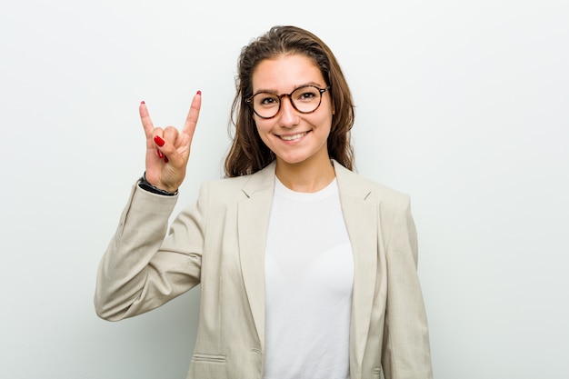 Jeune femme européenne montrant un geste de cornes comme un concept de révolution.