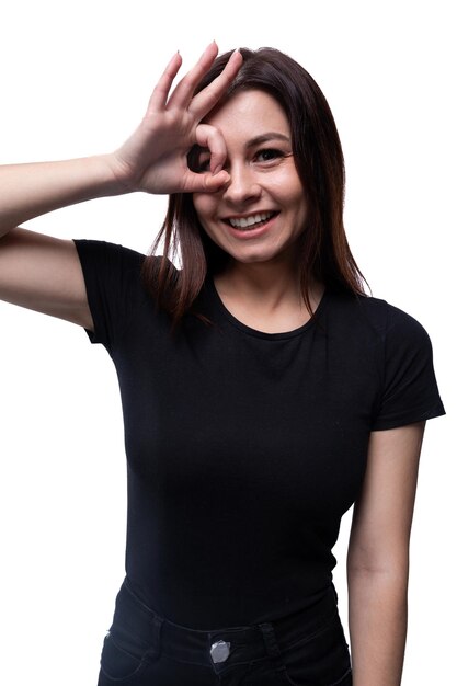 Une jeune femme européenne vêtue d'un t-shirt noir souriant sur un fond blanc avec un espace de copie