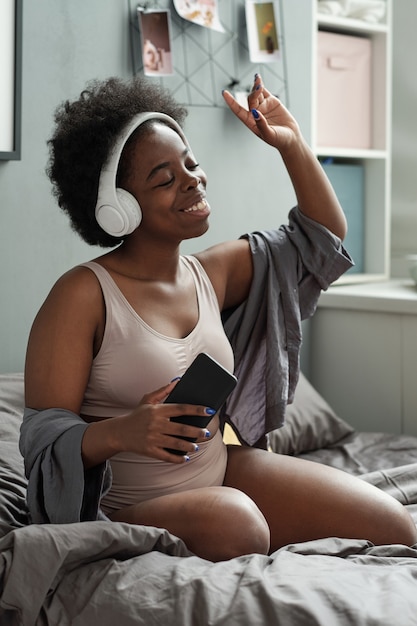 Jeune femme excitée appréciant sa musique préférée