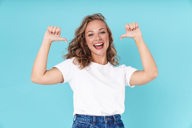 jeune femme excitée portant des vêtements décontractés debout isolée sur bleu, pointant du doigt elle-même