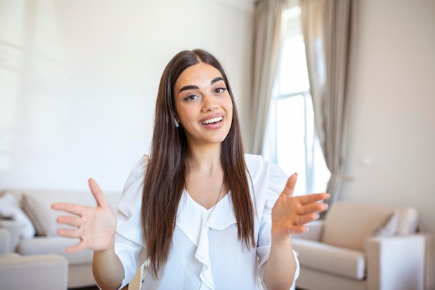 Jeune femme excitée regardant la caméra tenant une conversation amusante avec des collègues vue webcam en ligne Photo de tête d'une jeune femme avec un casque en riant s'amusant du bureau à domicile